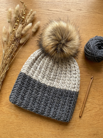 Styled flat lay of the Plume Grass crochet beanie with dried grasses and yarn